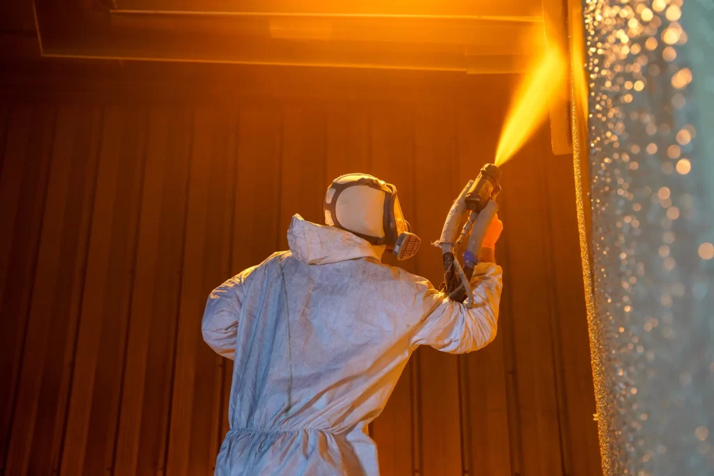 Technician applying polyurea to a shipping container